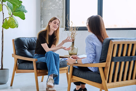 Young smiling girl patient in therapy session with social mental therapistの写真素材