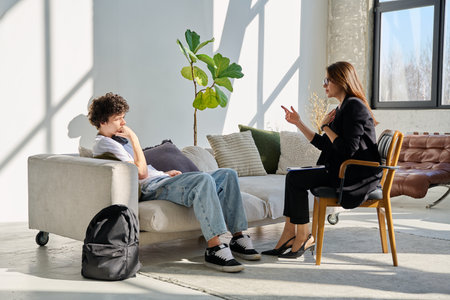 Young male patient talking to professional psychologist social worker counselorの写真素材