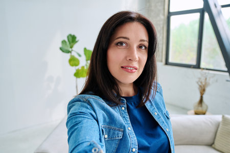 Selfie portrait happy beautiful woman in home interiorの写真素材
