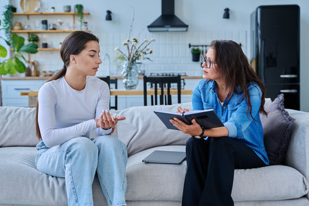 Female social worker working at home with teenage girlの写真素材