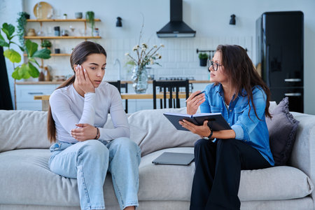 Serious teen girl in session in office of professional psychologist, therapistの写真素材