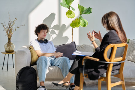Mental therapy session, young guy talking with female psychologist, in officeの写真素材