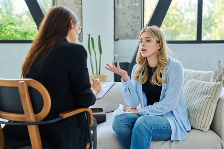 Young woman patient talking with female psychologist, mental counselorの写真素材