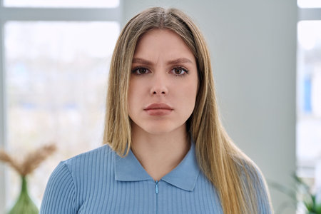 Headshot portrait of young serious woman looking at cameraの写真素材
