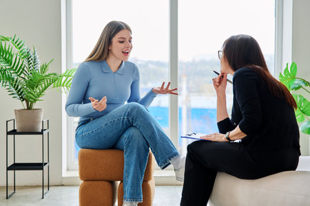 Young woman in a therapy session talking with a psychotherapistの写真素材