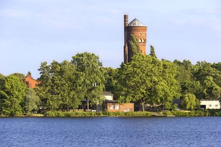 View to the peninsula of Hermannswerder, near the town of Potsdam, Brandenburg, Germany. Hermannswerder is situated between the River Havel and the the Lake Lake Templin. The navigable River Havel flows through the lake. So lakes are some neogothic buildiの写真素材
