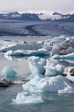 View of the famous glacier lagoon Jokulsarlon, below Vatnajokull. Icebergs floating on the open sea,...