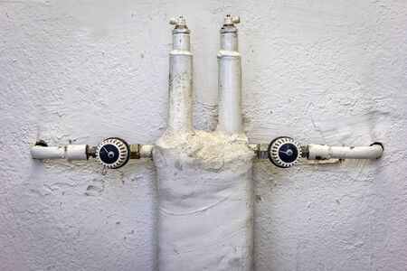 Old heating pipes and valves in an old factory building.の写真素材