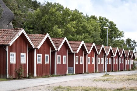 Close to the Swedish skerry archipelago in the province of Bohuslan, these traditional boathouses are located in a small harbor. Everything is stored there for fishing or they are rented as a holiday cottage.の写真素材
