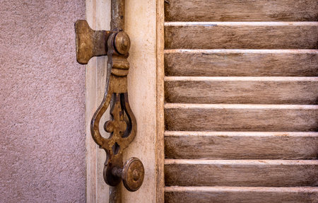 Detail of a metal window fitting. Seen in a village in Provence. It is a typical French fitting to...