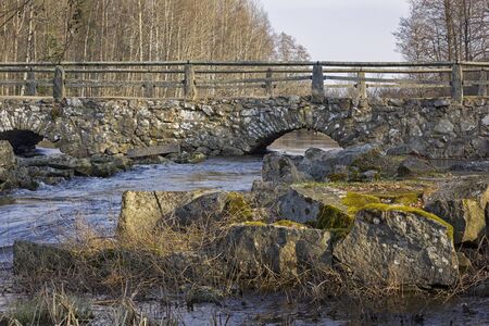 View of an old, historic stone bridge over a small river in the south of Sweden. This architecture is typical there.の写真素材