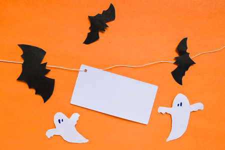 Happy Halloween holiday concept. Halloween decorations, bats and spooky on an orange background. Card with frame for text. Copy spaceの写真素材
