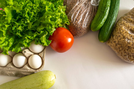 Food for donations. Healthy food on white background. spaghetti, buckwheat, eggs, cucumber, tomato,...