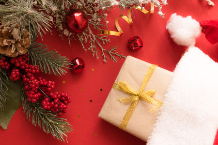 Beautiful Christmas composition with gift box tied with a ribbon, presents, Santa hat and fir...