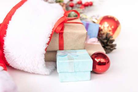 Beautiful Christmas composition with gift box tied with a ribbon, presents, Santa hat and fir branches on white background. Flat layの写真素材