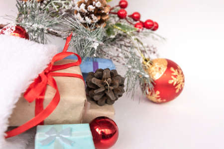 Beautiful Christmas composition with gift box tied with a ribbon, presents, Santa hat and fir branches on white background. Flat layの写真素材