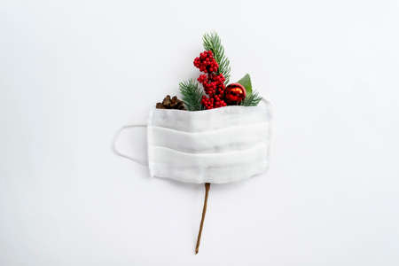 Single fir branches and medical mask on white background. Christmas minimalism. Flat lay with copy space.の写真素材