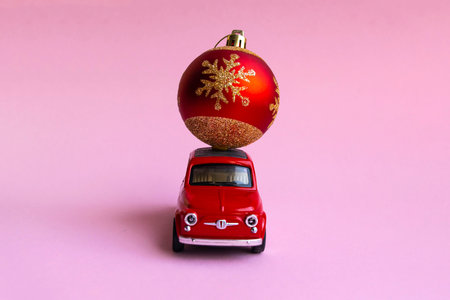 Minsk, Belarus, 23 november 2020. Concept christmas background. Red retro toy car delivering...