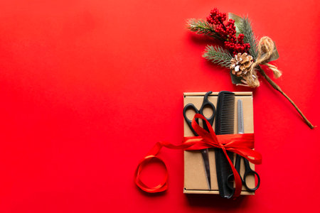 Flat lay Christmas composition. Hairdressing tools, gift and Christmas decor on a red background. Xmas, happy new year. copy space.の写真素材