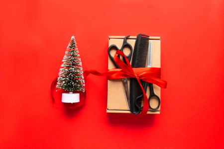 Flat lay Christmas composition. Hairdressing tools, gift and Christmas decor on a red background. Xmas, happy new year. copy space.の写真素材