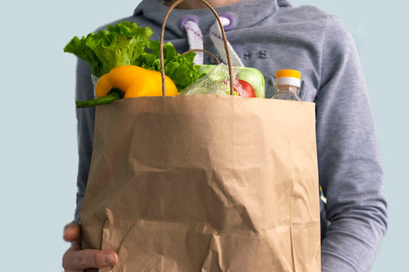 Healthy food delivery during coronavirus. Food donation in women hands in paper bag package. Help...