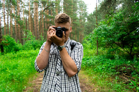 Boy, a male tourist take camera, photos in a gray-and-white checked shirt cap with a gray backpack,...