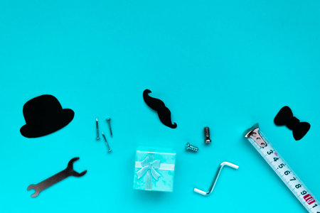 Happy Father's Day concept. Composition of paper decor and gift box on blue background. Flat lay with copy spaceの写真素材