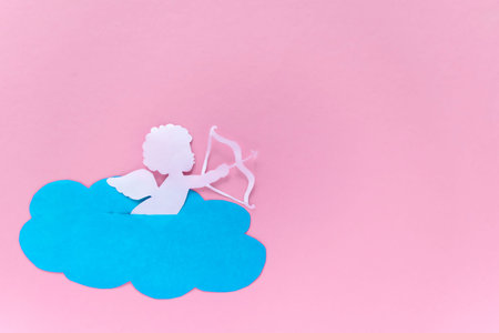 valentines day consept. cupid aiming in heart on pink background. valentine's day card. flat lay....