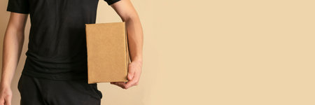 banner delivery man in black clothes hold a cardboard box.