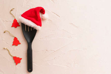 Christmas and new year composition with kitchen tools and Santa hat on gray concrete background. Xmas cooking concept. Top view with copy space for textの写真素材