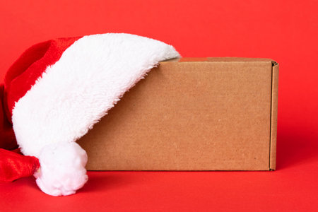 gift box with red santa hat on red background. present for Christmas, new year