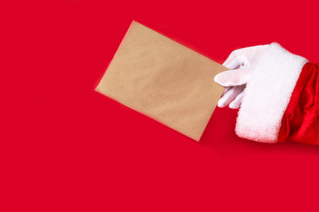 letter in santa hand on red background. present for Christmas, new year, copy spaceの写真素材