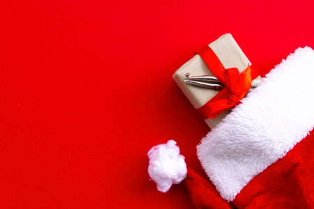 Christmas and new year concept with knitting tool in santa hat on red background