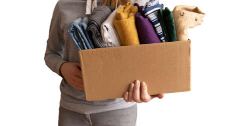 Woman packs clothes in boxes for donating. Help peopleの写真素材