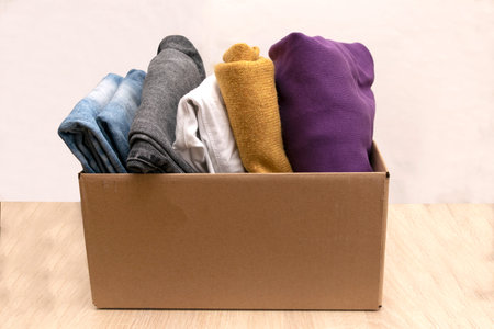 Woman packs clothes in boxes for donating.