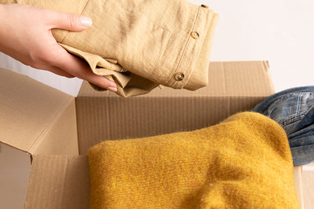 Woman packs clothes in boxes for donating.の写真素材