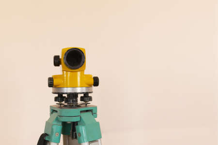 Geodesy level device on a tripod with ruler on the background a concrete pink wall.の写真素材