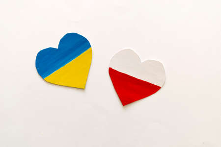 The concept of friendship and support countries , heart in the colors of the flag of Ukraine and Poland on grey backgroundの写真素材