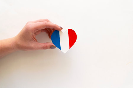 Paper heart in the colors of the flag of France in female hands.の写真素材
