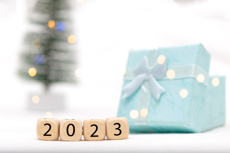 Decorative blue gift box on white background with bokeh of lights and numbers of year 2023の写真素材