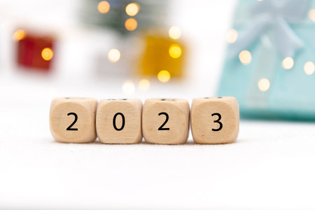 Decorative blue gift box on white background with bokeh of lights and numbers of year 2023