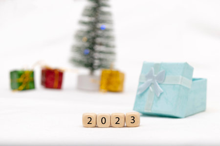 Decorative blue gift box on white background with bokeh of lights and numbers of year 2023
