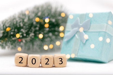 Decorative blue gift box on white background with bokeh of lights and numbers of year 2023の写真素材