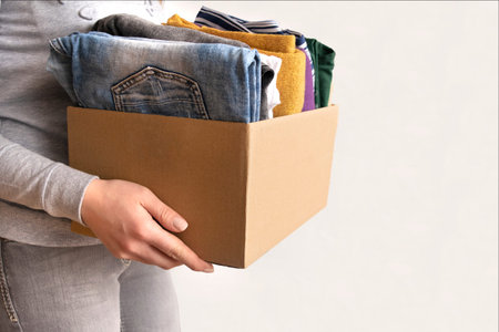 Woman packs clothes in boxes for donating.