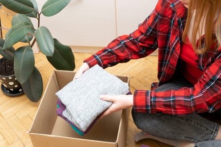 Person packs clothes in boxes for donatingの写真素材