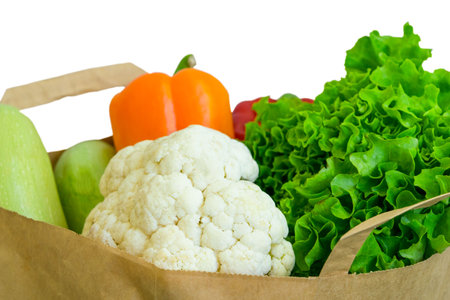 Fresh food vegetables donation isolated on background in paper bag package. Healthy food delivery during coronavirus.の写真素材