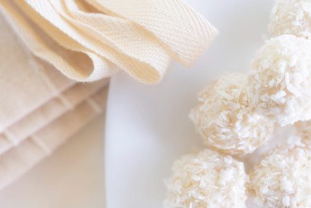 Candies in plate covered by chocolate, shredded coconut and kitchen towel on rustic wooden...