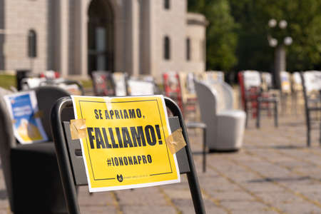 Restaurant strike against working for a limited number of people. Sign banner on chair If we open we fail. Reopening after coronavirus pandemic lockdown and quarantine. Milan, Italy - May 8, 2020のeditorial素材
