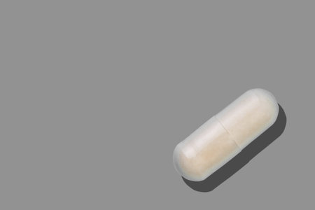 Medical pill, pharmaceutical medicine capsule. Painkiller, vitamin, antibiotic, probiotic on grey...