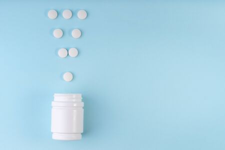 Exclamation point sign, mark from pharmaceutical medicine pills. Creative layout of tablets and bottle on blue. Exclamation symbol. Medicine, healthcare concept. Copy space, flat layの写真素材